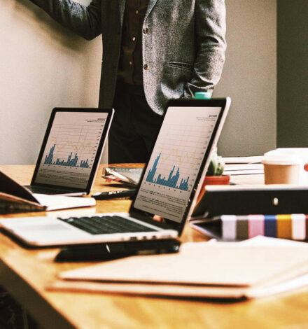 Office workers sat down with their laptops, looking at charts.